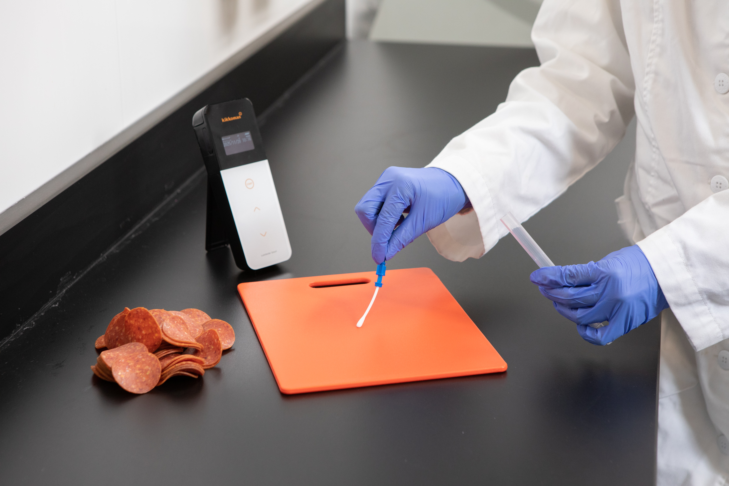 cutting board being swabbed by lab tech