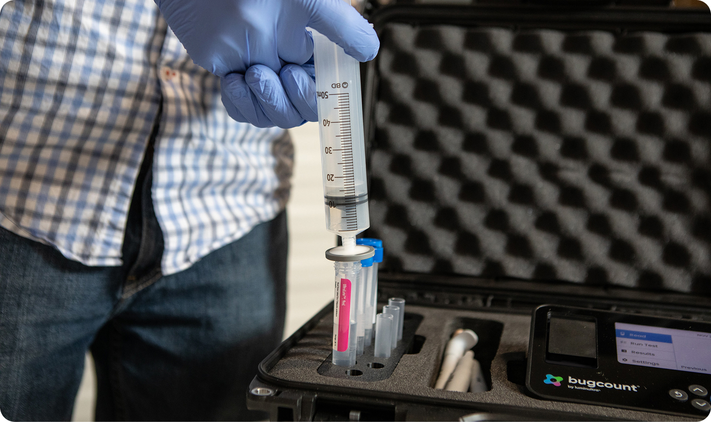 person with liquid syringe, putting fluid into a tube