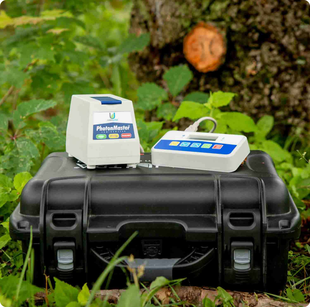 Photonmaster device, sitting on top of a hard case outside in nature