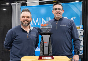 LuminUltra representatives stand beside a trophy for winning the MP Innovation in Corrosion award.