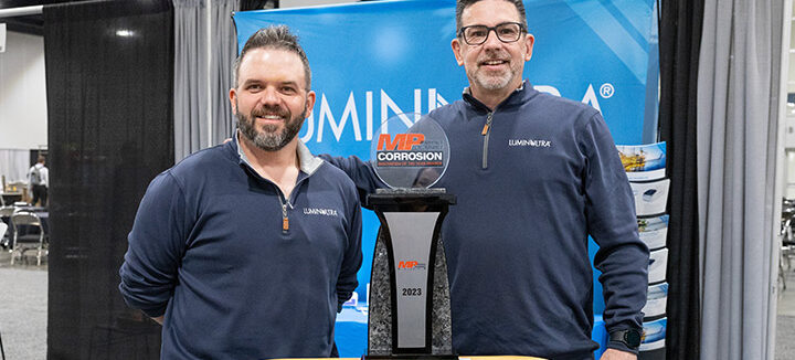 LuminUltra representatives stand beside a trophy for winning the MP Innovation in Corrosion award.